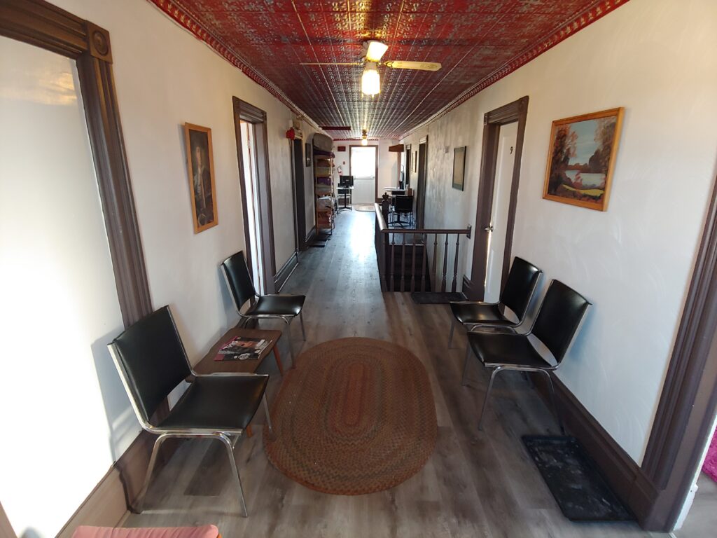 hallway with chairs and red tin ceiling