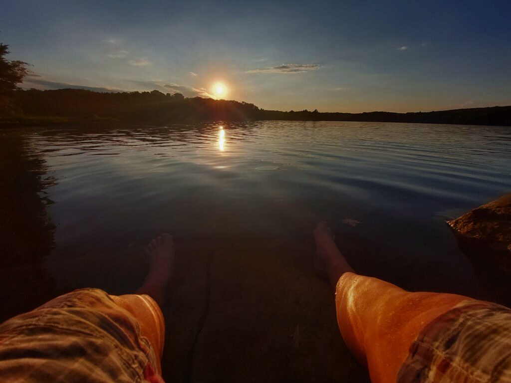 legs disappearing into waters of Bay Lake at sunset