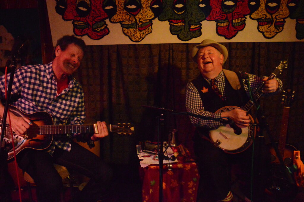 Banjo and guitar players laughing