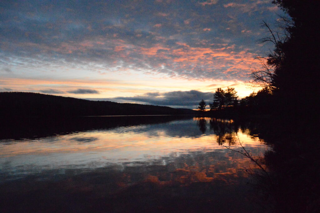 underlit clouds at sunset reflected in the waters of hay lake