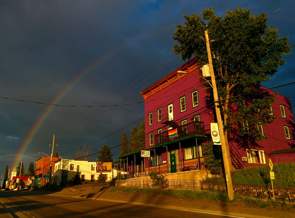 downtown Maynooth under rainbow with Arlington in foreground bearing Pride flag