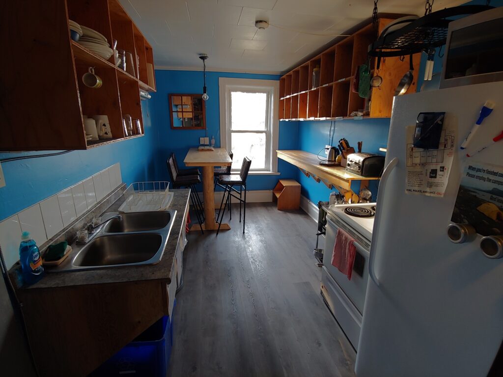 blue kitchen with double sink, fridge, stove, cubby holes