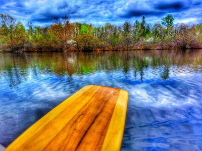 Clouds, Trees & River with a paddle in the foreground