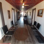 hallway with chairs and red tin ceiling