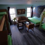 Shared Dorm three bunk beds, one single bed, love seat, coffee table, two chairs, wolf mural