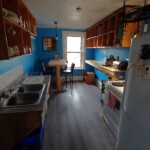 blue kitchen with double sink, fridge, stove, cubby holes