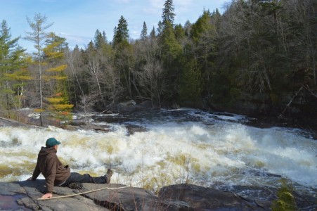 fella sitting in front of raging waterfalls